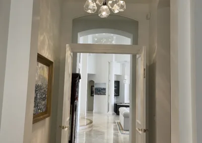 A hallway in a home with a chandelier.