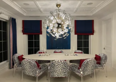 A dining room with blue and red chairs and a chandelier.