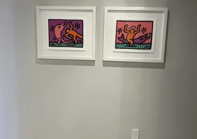 Two framed pieces of art hanging in a room.
