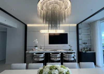 A modern dining room with a chandelier hanging over the table.