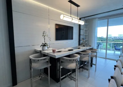 A modern kitchen with white counter tops and stainless steel appliances.