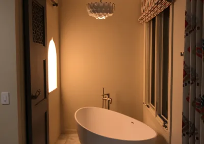 A white bathtub in a bathroom with a chandelier.
