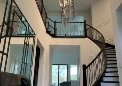 A staircase in a modern home with a chandelier.
